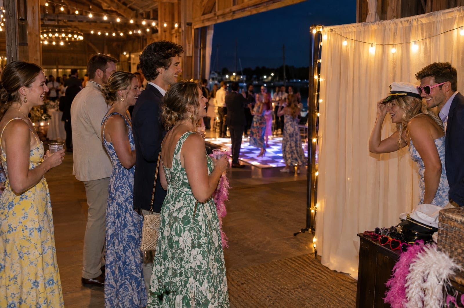 Example scene: wedding guests waiting their turn at a photo booth corner hung with string lights